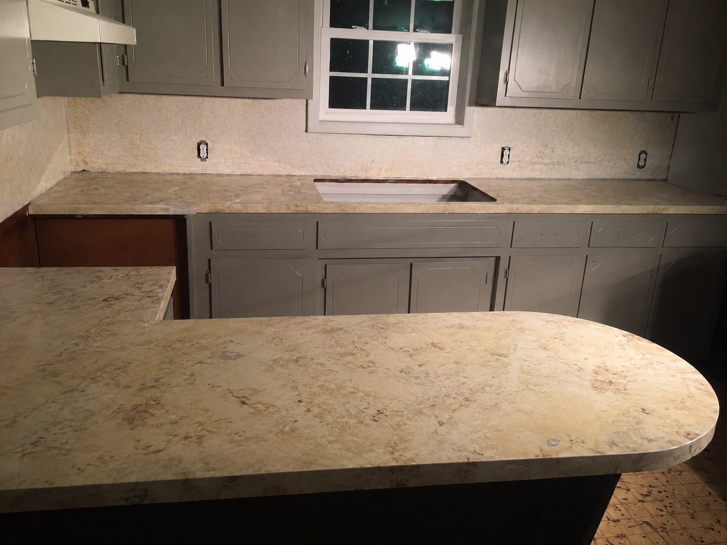 Dated beige speckled kitchen countertop and backsplash before refinishing