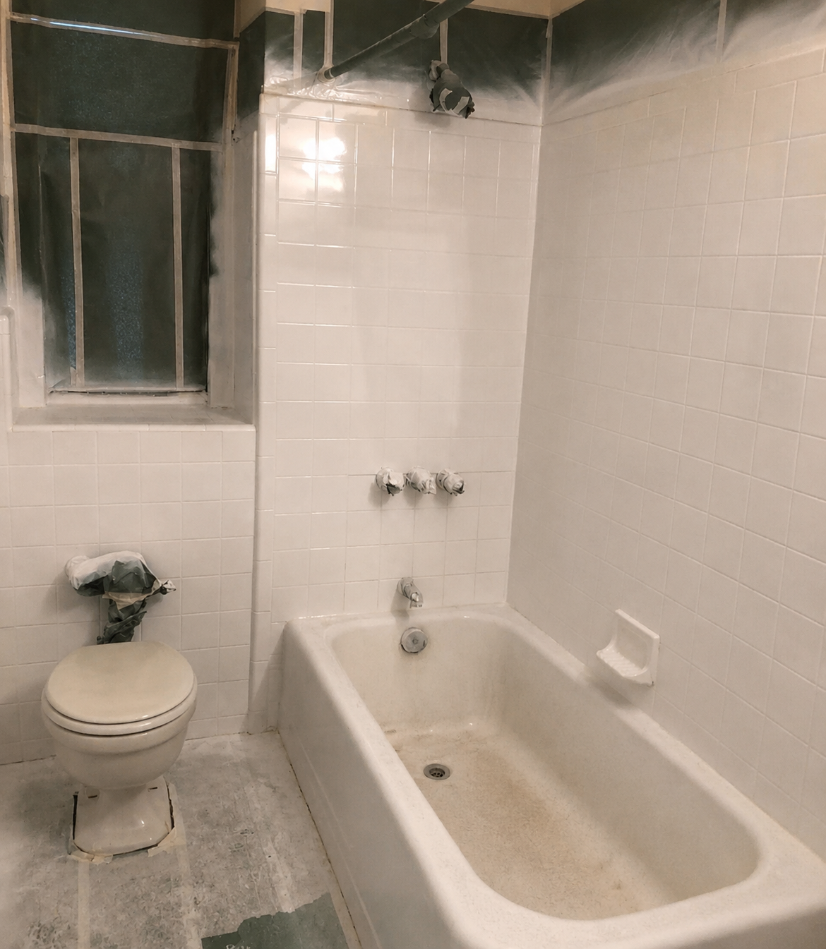 Worn tub and tile shower surround masked off before EverStone refinishing