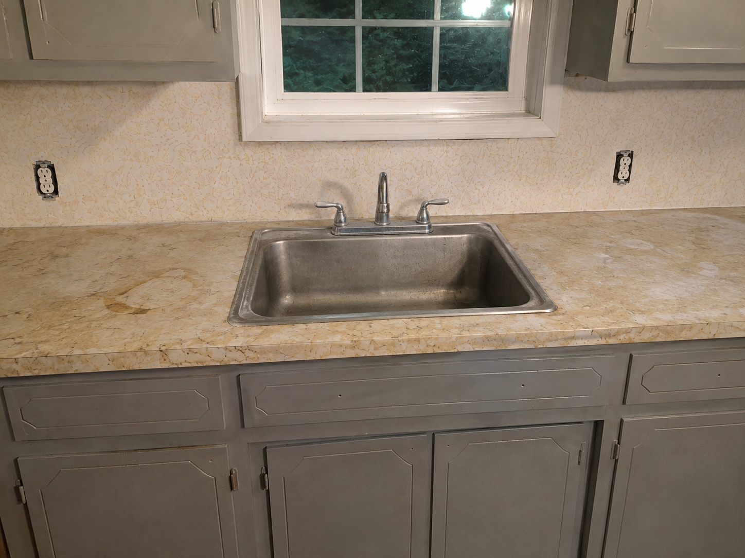 Stained yellowed laminate kitchen countertop and backsplash with dated finish before resurfacing