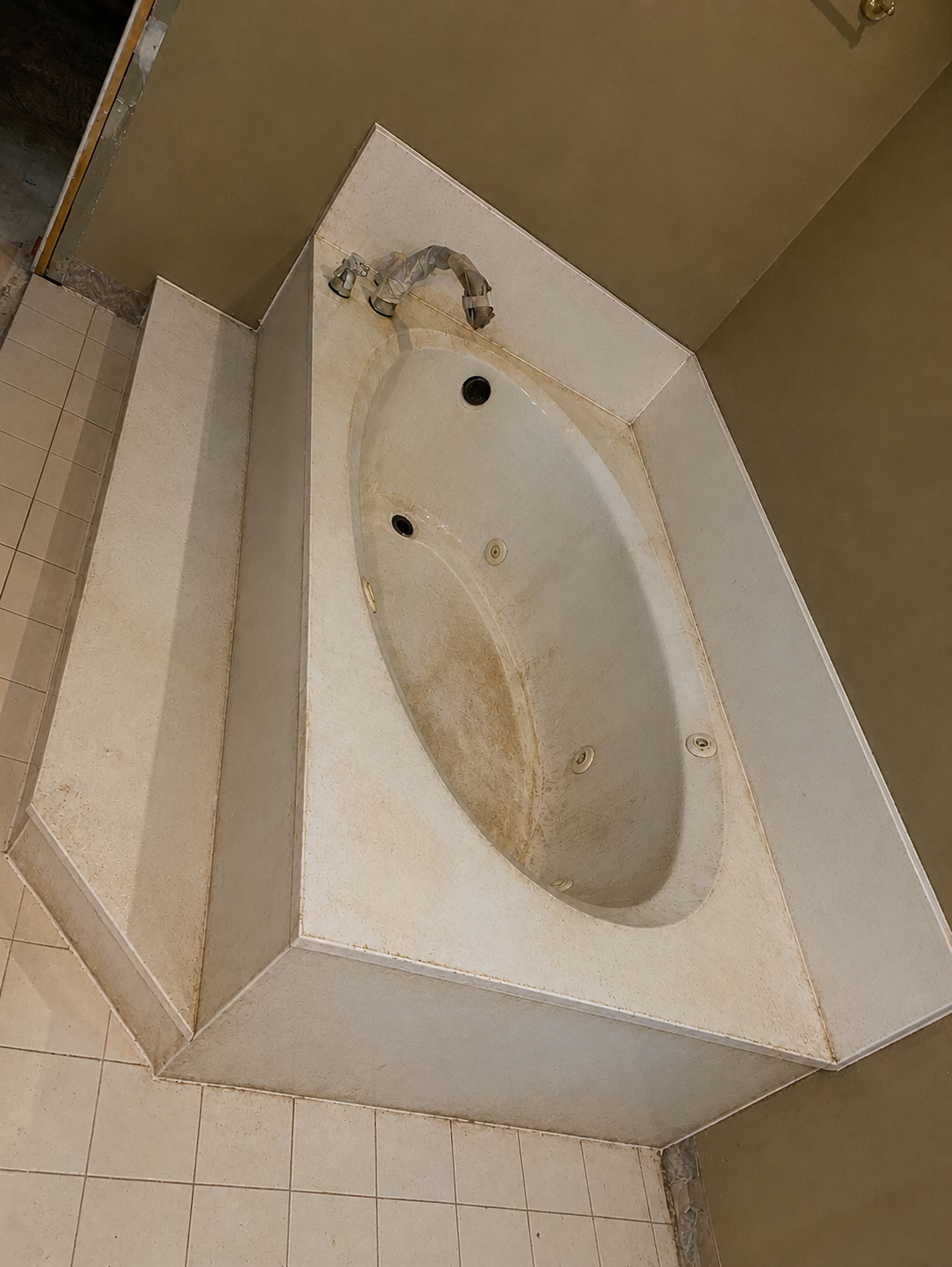 Stained yellowed jetted bathtub and cultured marble surround before EverStone refinishing